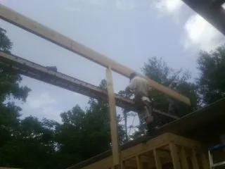 Carpenter setting a ridge beam over a new addition frame — Ice Dam Removal by Roofing Brothers in Monroeville